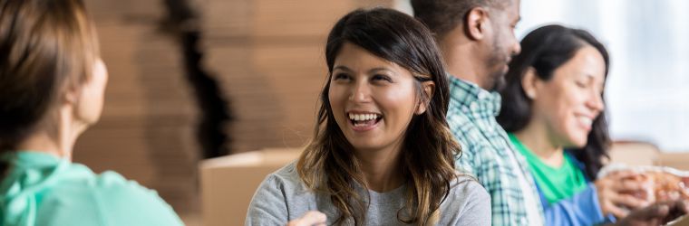 Social workers smiling while volunteering at a food bank