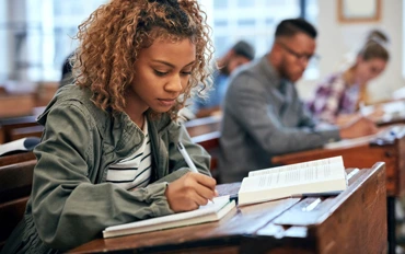 female student taking notes in class